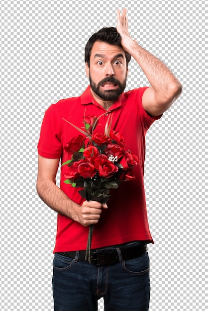 Handsome man holding flowers having doubts