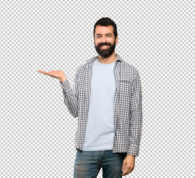 Handsome man with beard holding copyspace imaginary on the palm to insert an ad