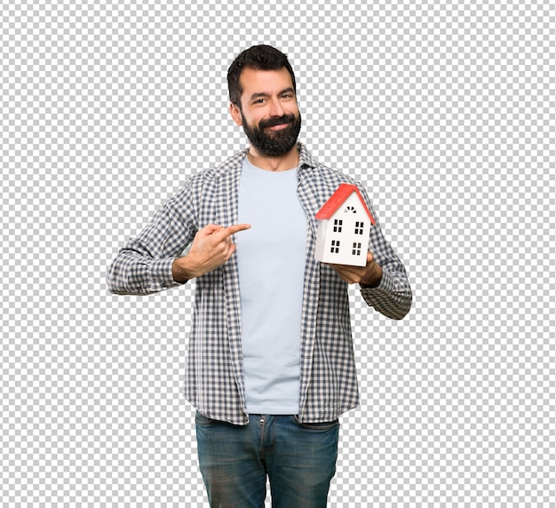 Красивый мужчина с бородой держит маленький домик