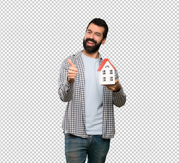 Handsome man with beard holding a little house