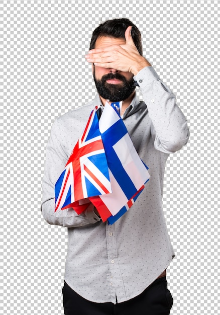 PSD Красивый мужчина с бородой, держащей много флагов и закрывая глаза