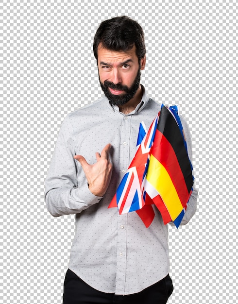 PSD handsome man with beard holding many flags and making surprise gesture