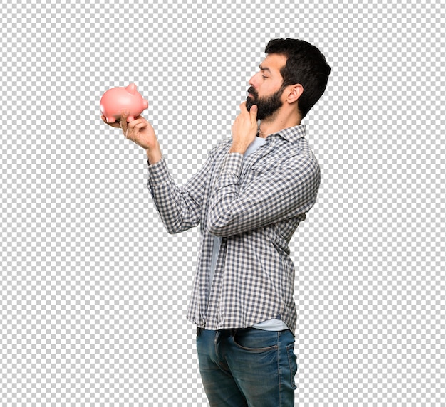 Handsome man with beard holding a piggybank