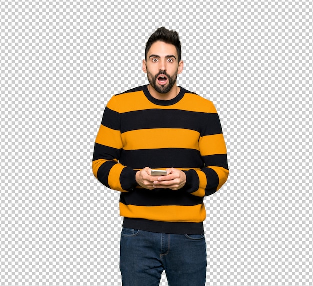 Handsome man with striped sweater surprised and sending a message