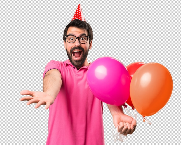 Handsome young man holding balloons