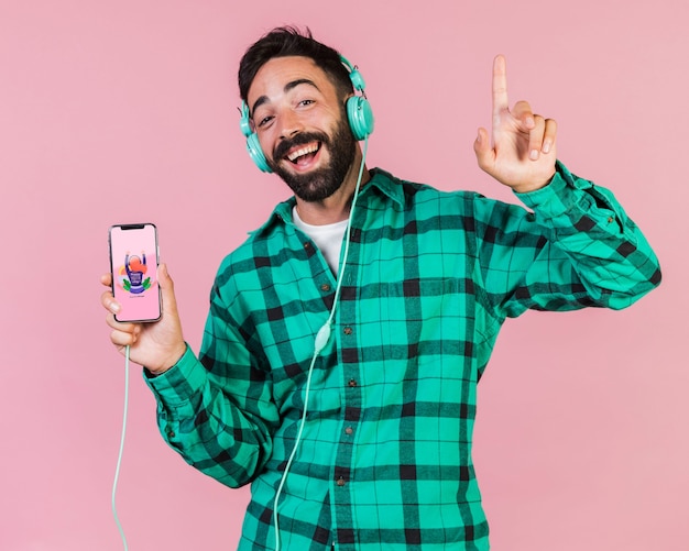 Счастливый бородатый человек с наушниками и сотовый телефон макет