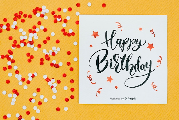 Happy birthday on card with red and white confetti