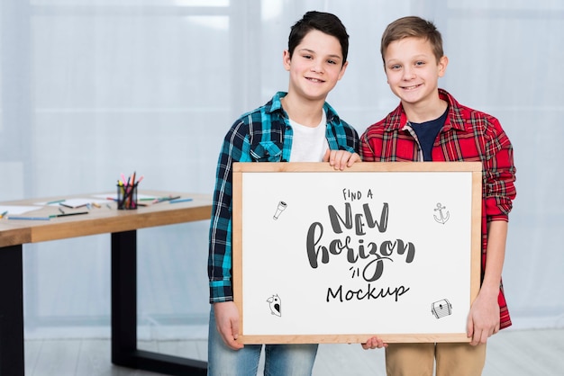 Happy children holding mock-up sign