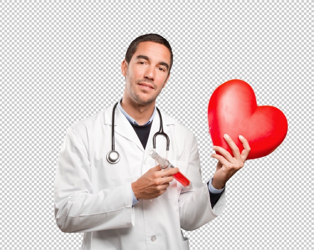 Happy doctor holding a toy heart and a syringe against white background