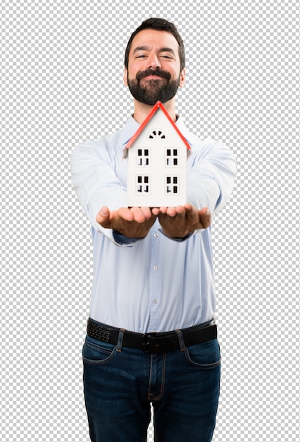Happy Handsome man with beard holding a little house