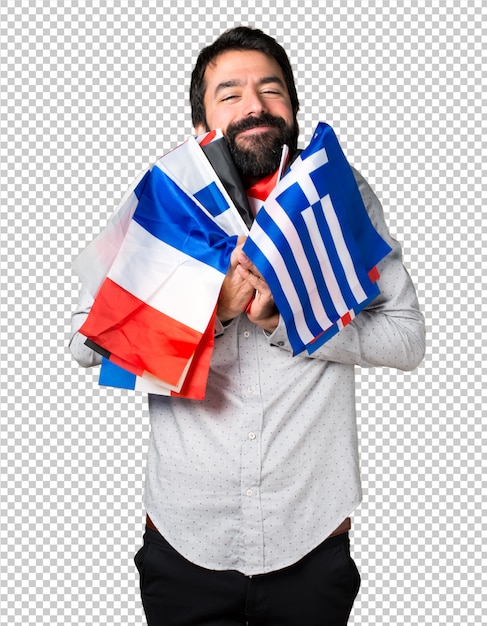 Happy handsome man with beard holding many flags