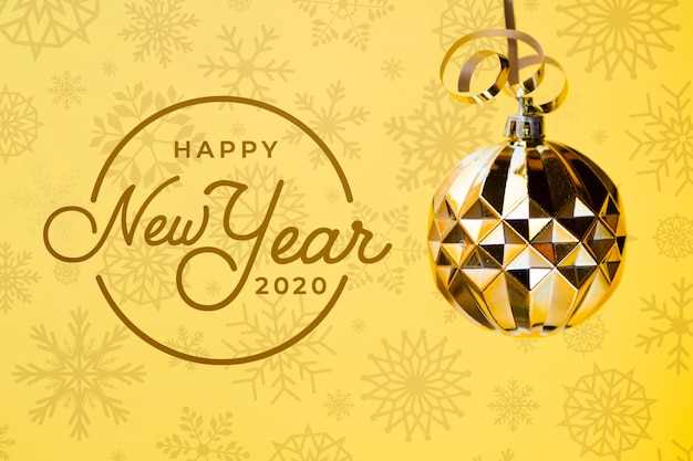 黄色の背景にゴールデンクリスマスボールと幸せな新年2020