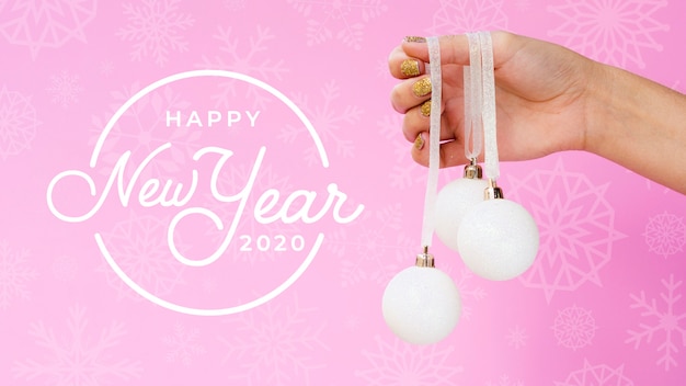 Felice nuovo anno 2020 con palla di natale bianco su sfondo rosa