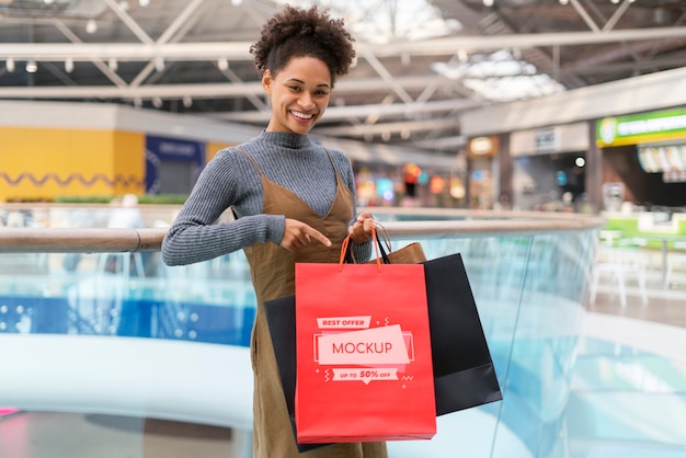 ショッピングバッグのモックアップと幸せな女性