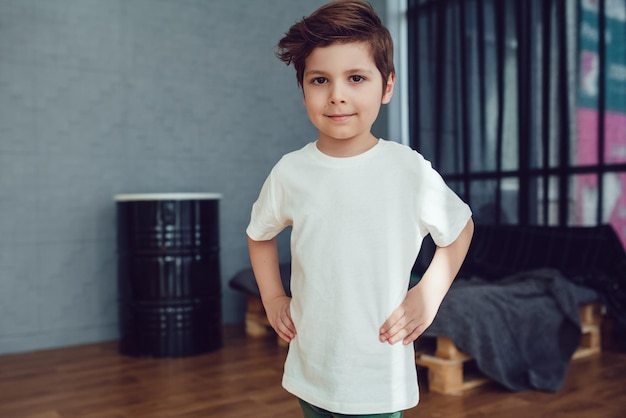 Happy young boy in white t-shirt posing for a photo