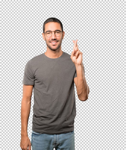 Happy young man doing a crossed fingers gesture