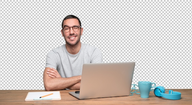 Happy young man sitting at his desk and winking an eye