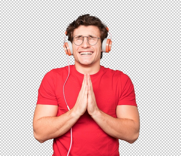 Happy young man using headphones and a smartphone and making a gesture of praying