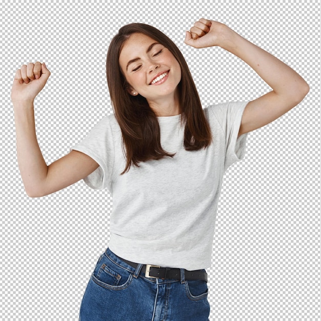 Happy young woman dancing and having fun smiling and expressing positive emotions standing over white wall