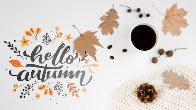 Hello autumn lettering next to cup of coffee
