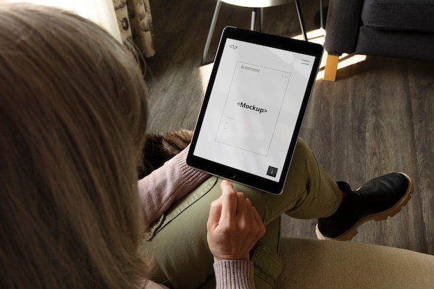 PSD adulto ad alto angolo che si rilassa con il mockup del tablet