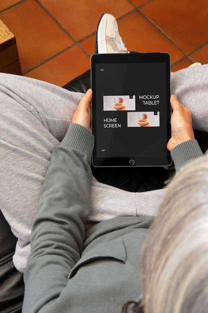 Adulto ad alto angolo che si rilassa con il mockup del tablet