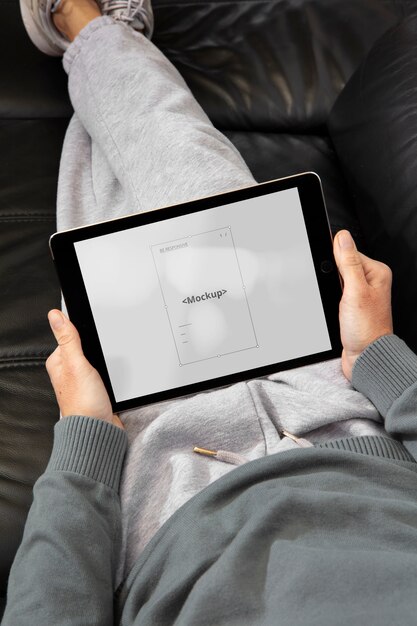 PSD adulto ad alto angolo che si rilassa con il mockup del tablet