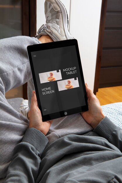 high angle adult relaxing with tablet mockup