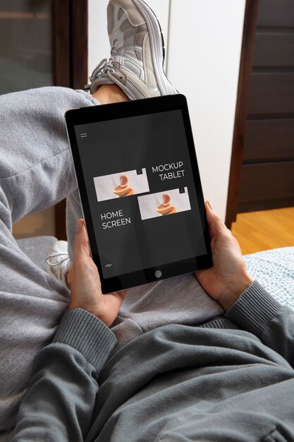 High angle adult relaxing with tablet mockup