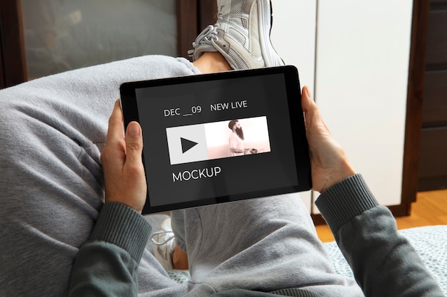 PSD adulto ad alto angolo che si rilassa con il mockup del tablet