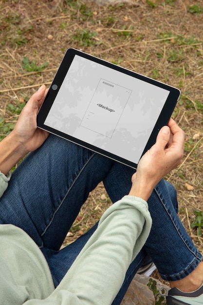 PSD adulto ad alto angolo che si rilassa con il mockup del tablet