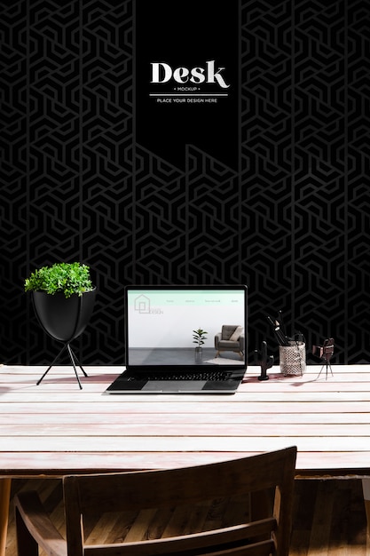 high angle of desk with laptop and plant pot