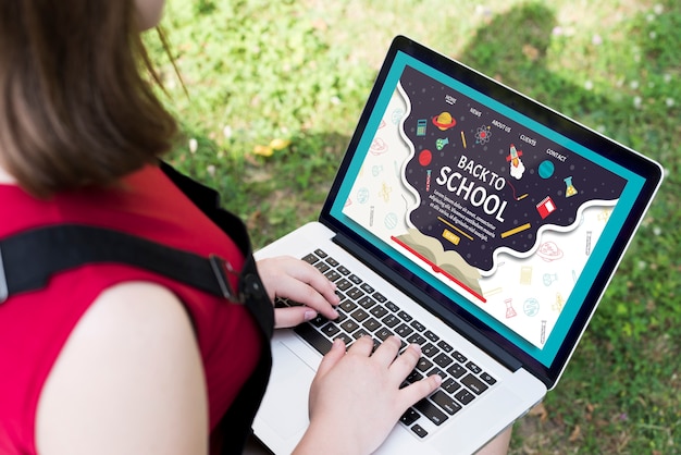 High angle girl using laptop outside mock-up