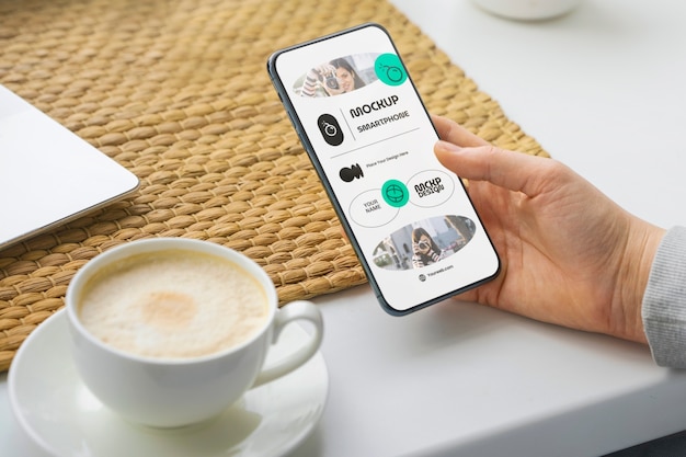 PSD 스마트폰과 커피가 있는 높은 각도의 손