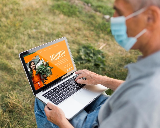 PSD high angle of man on laptop in park