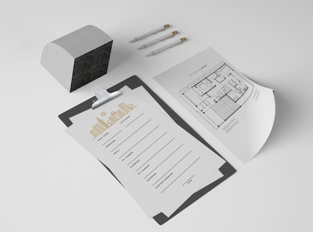 high angle of notepad with papers and plan