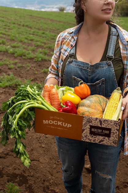 PSD high angle  woman  holding a box in nature