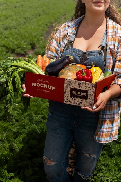 PSD high angle  woman  holding a box in nature