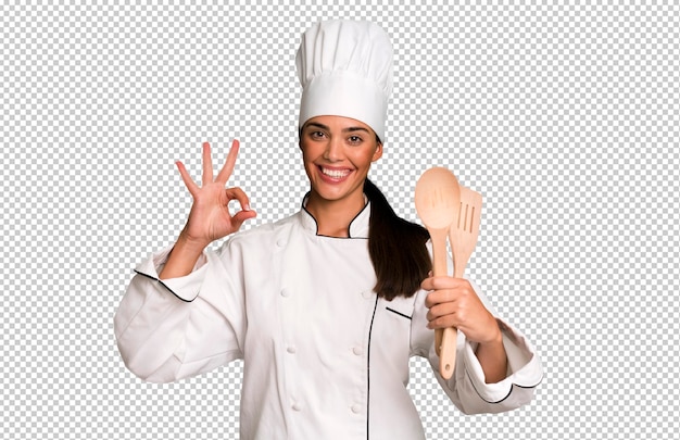 Испаноязычная симпатичная молодая взрослая и выразительная женщина-повар с кухонными инструментами