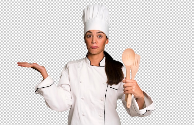 PSD Испаноязычная симпатичная молодая взрослая и выразительная женщина-повар с кухонными инструментами