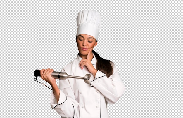 Испаноязычная симпатичная молодая взрослая и выразительная женщина-шеф-повар и ручной блендер