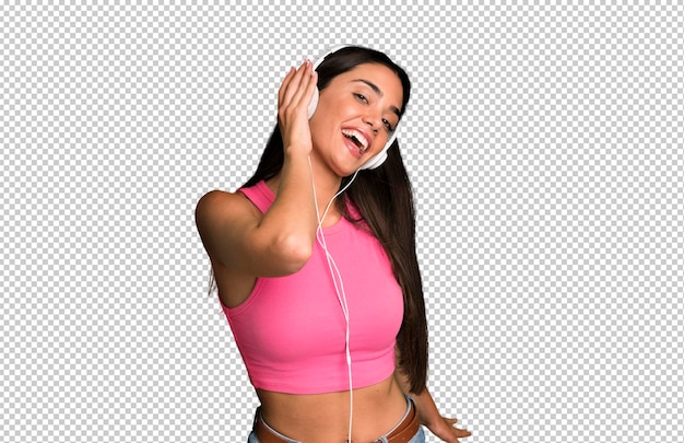 PSD hispanic pretty young adult and expressive woman listening music and dancing with headphones