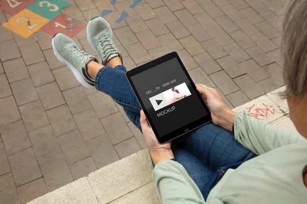 Hoge hoek volwassen ontspannen met tablet mockup