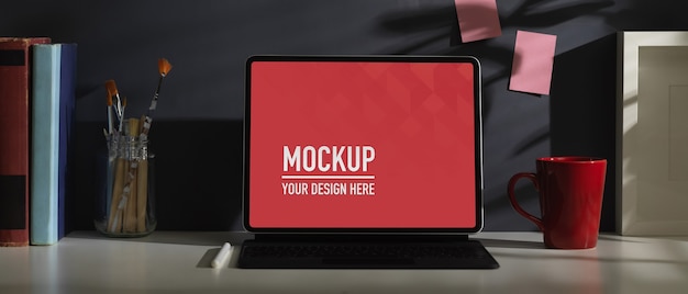 Scrivania da ufficio con mockup tablet, tastiera, cancelleria e decorazioni