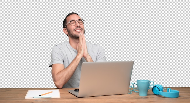 hopeful young man sitting at his desk
