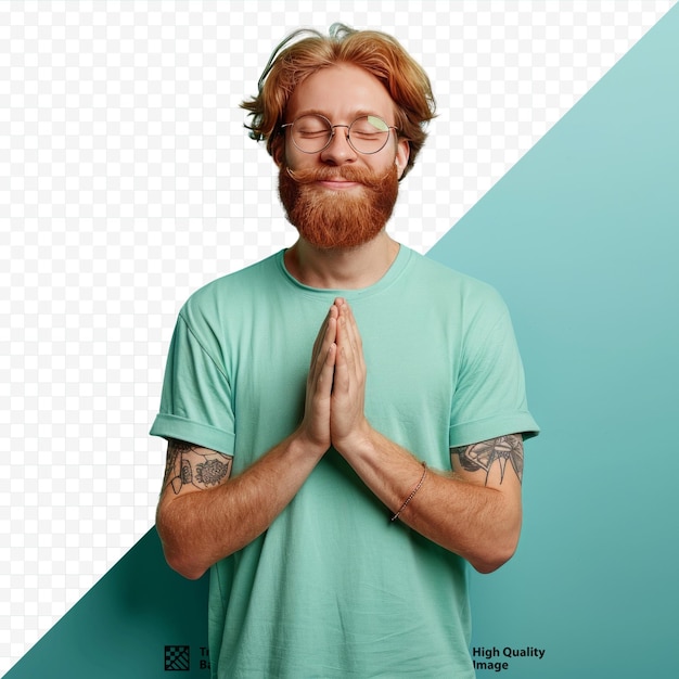 Hopelijke roodharige man met baard met bril en t-shirt die handen vasthoudt in een namaste of smeekgebaar en naar rechts kijkt glimlachend en bedankend staand over een turquoise geïsoleerde achtergrond