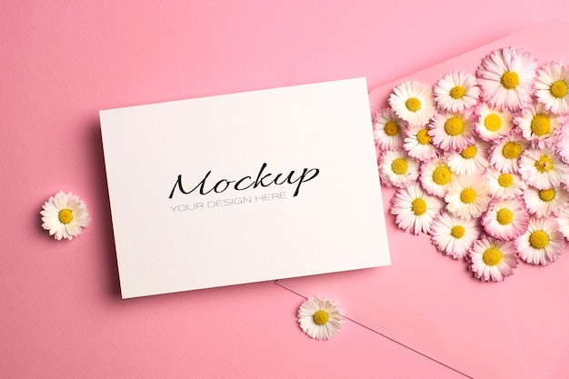 Invitation or greeting card mockup with envelope and daisy flowers on pink