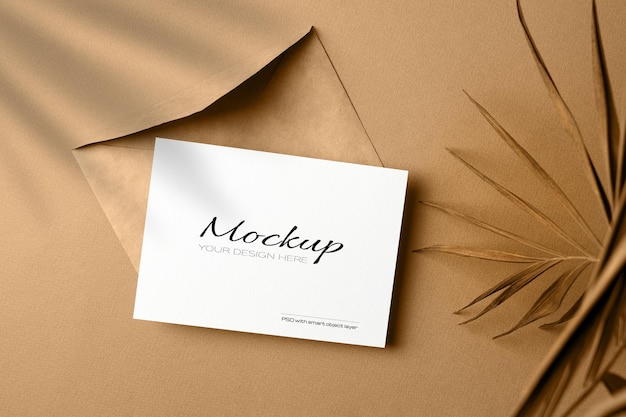 Invitation or greeting card mockup with envelope and dry nature palm leaf