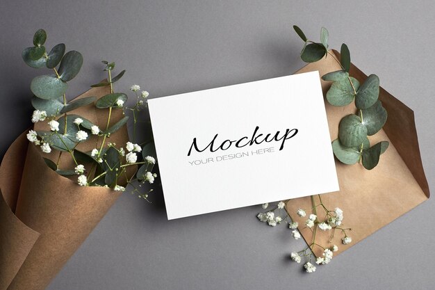 Invitation or greeting card mockup with envelope and eucalyptus and hypsophila flowers