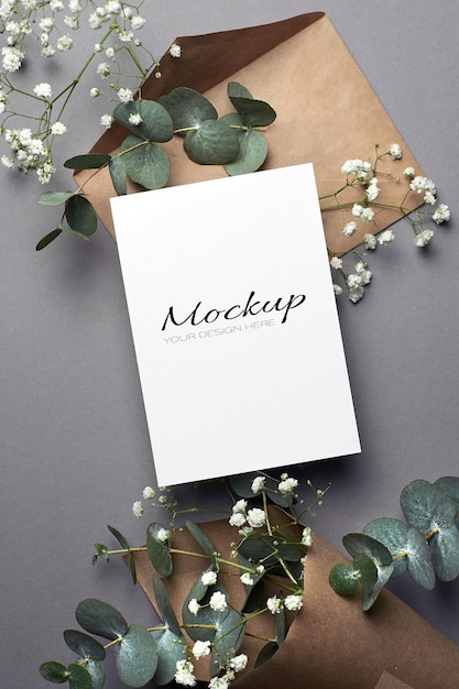 PSD invitation or greeting card mockup with envelope and eucalyptus and hypsophila flowers